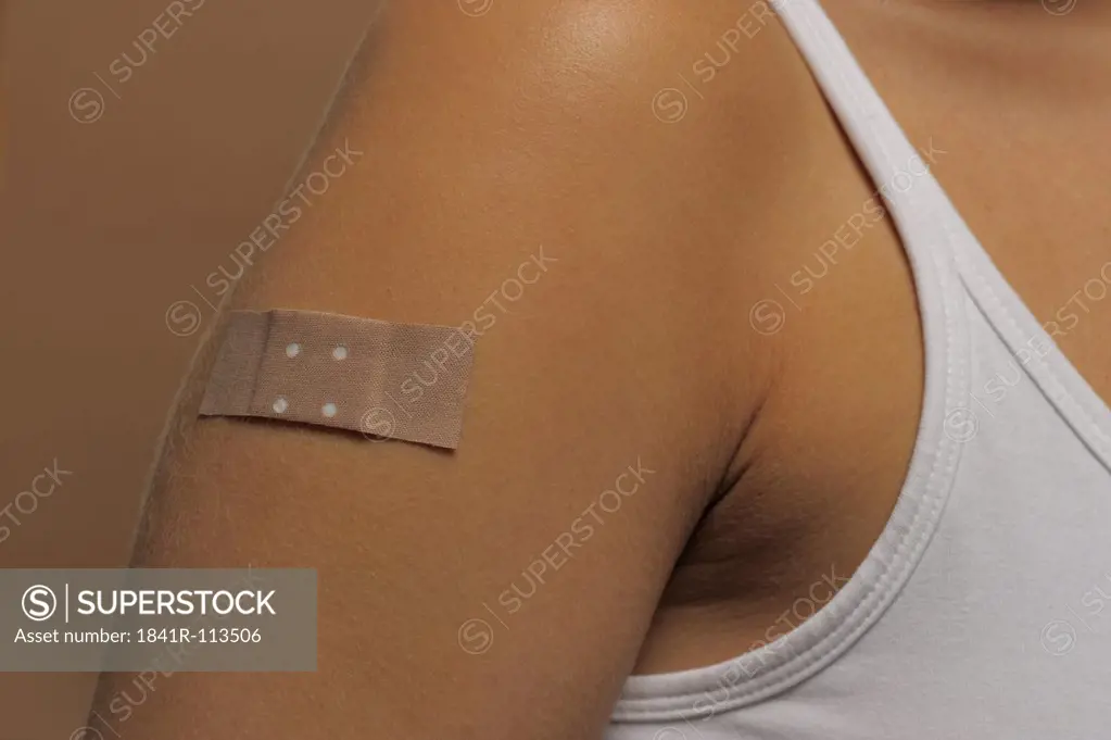 Young woman with a plaster on her upper arm