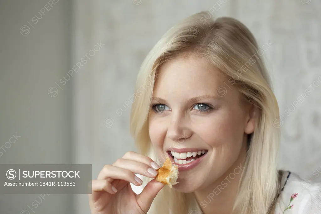 Young woman eating a croissant