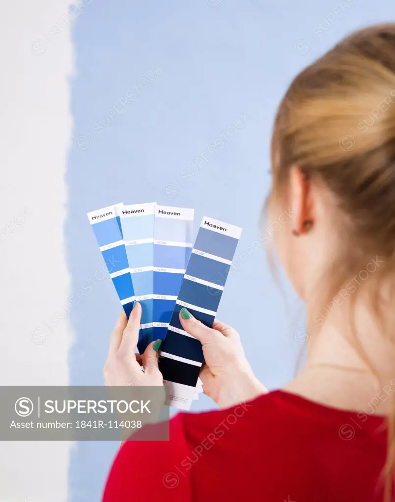 Young woman standing with color samples at a wall