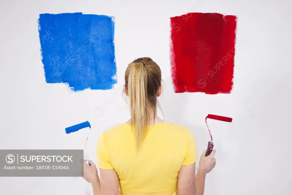 Young woman painting a wall
