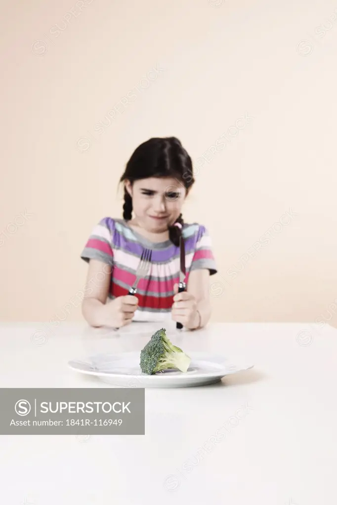 Girl refusing to eat broccoli