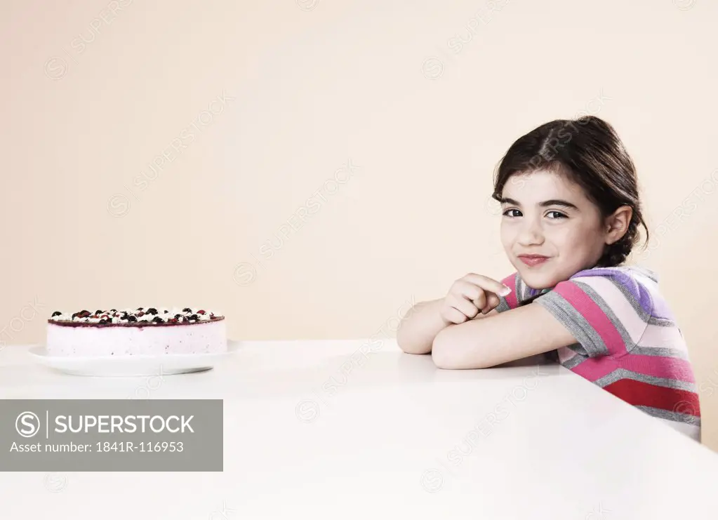 Girl sitting at table with gateau