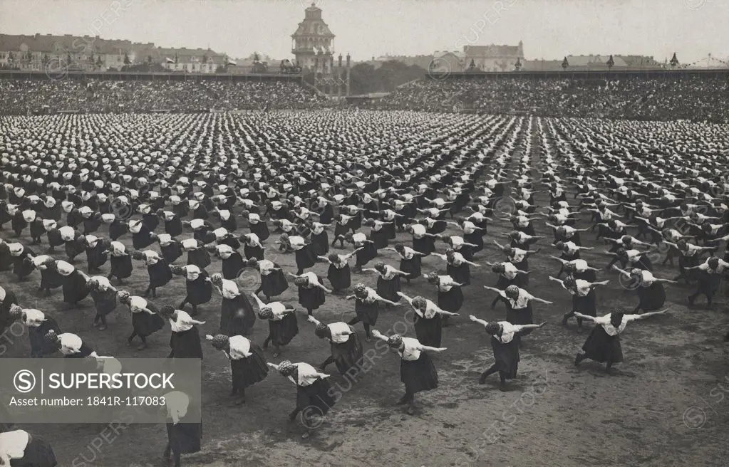 Historical picture of women doing gymnastics in a stadium