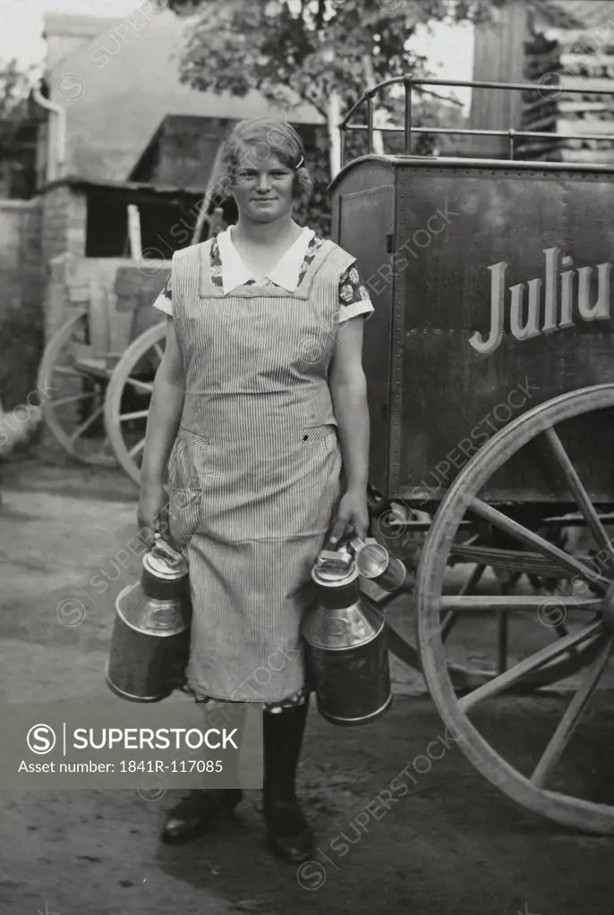 Historical picture of a farmers wife with milk cans
