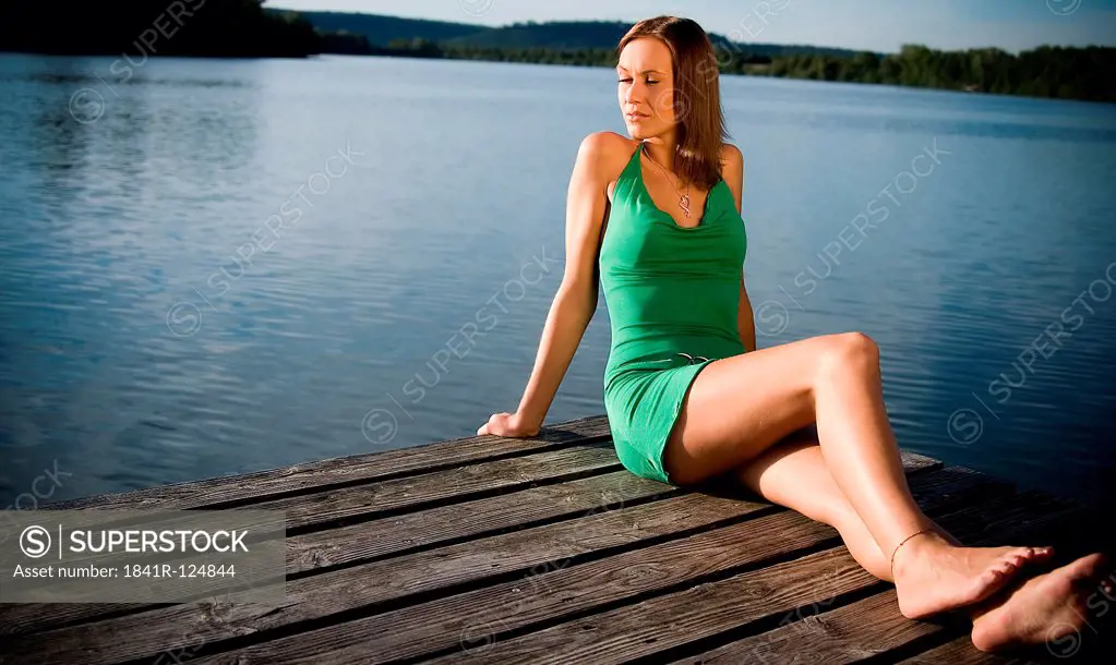 Young woman in green dress at a lake