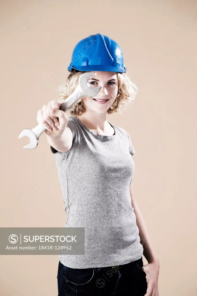 Teenage girl with hard helm and hand tool