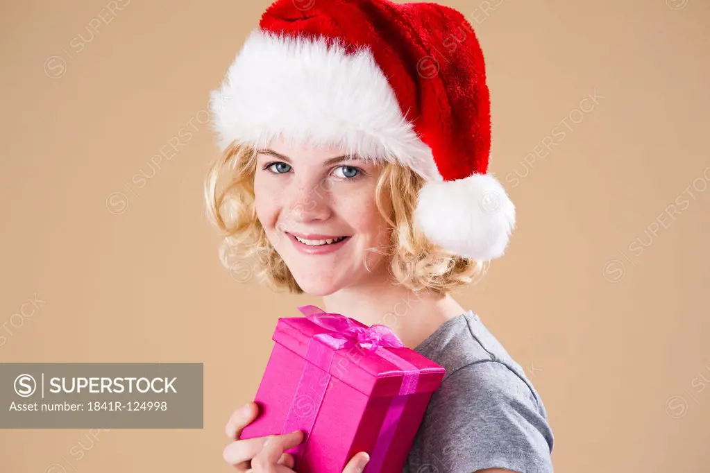 Teenage girl with santa's hat and present