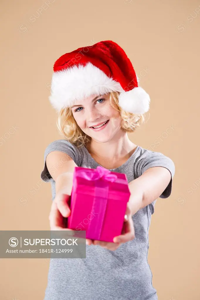 Teenage girl with santa's hat and present
