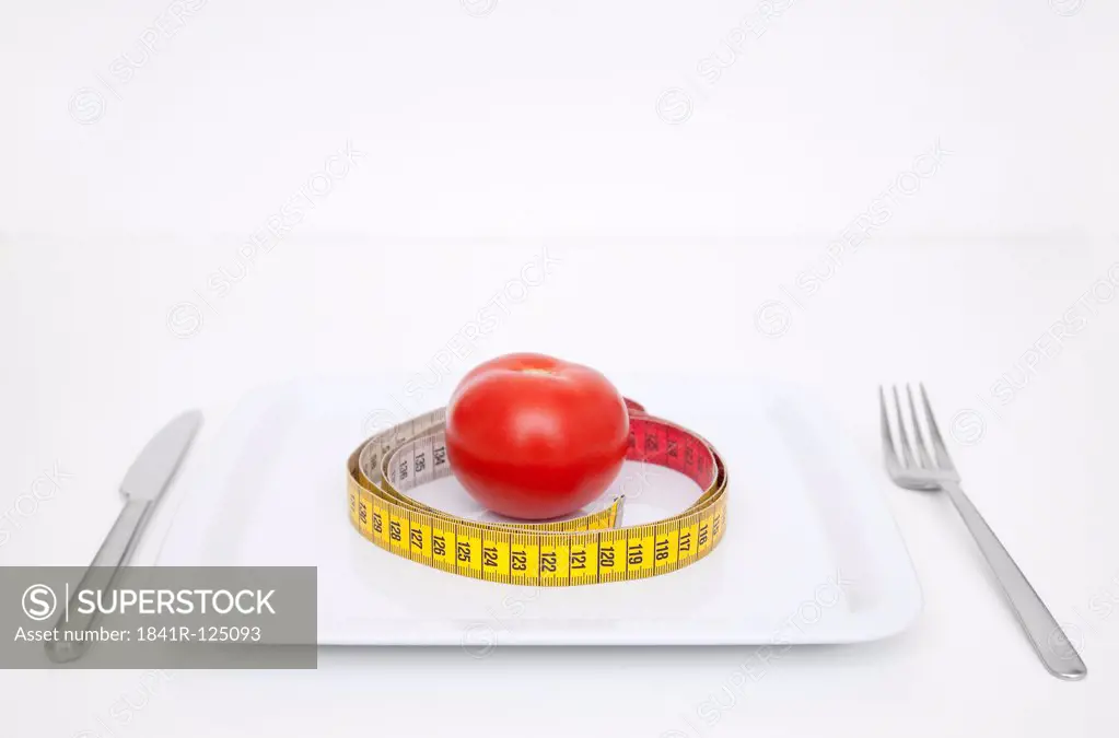 Plate with tomato and tape measure