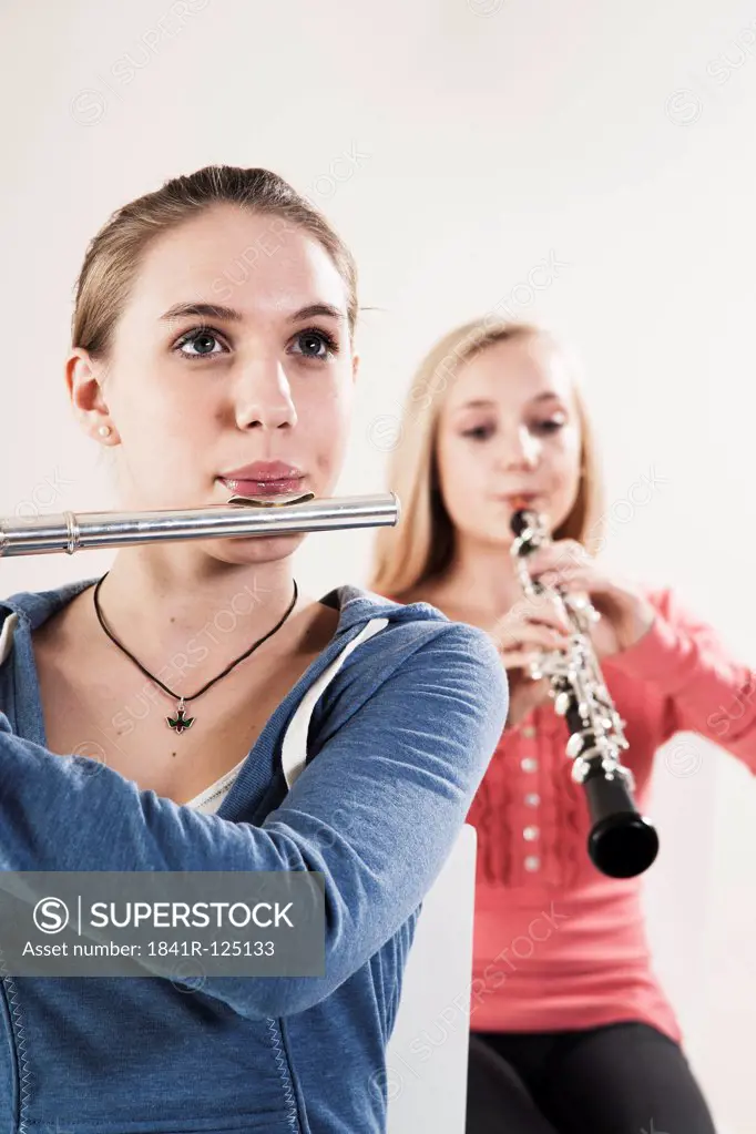 Two teenage girls playing oboe and transverse flute