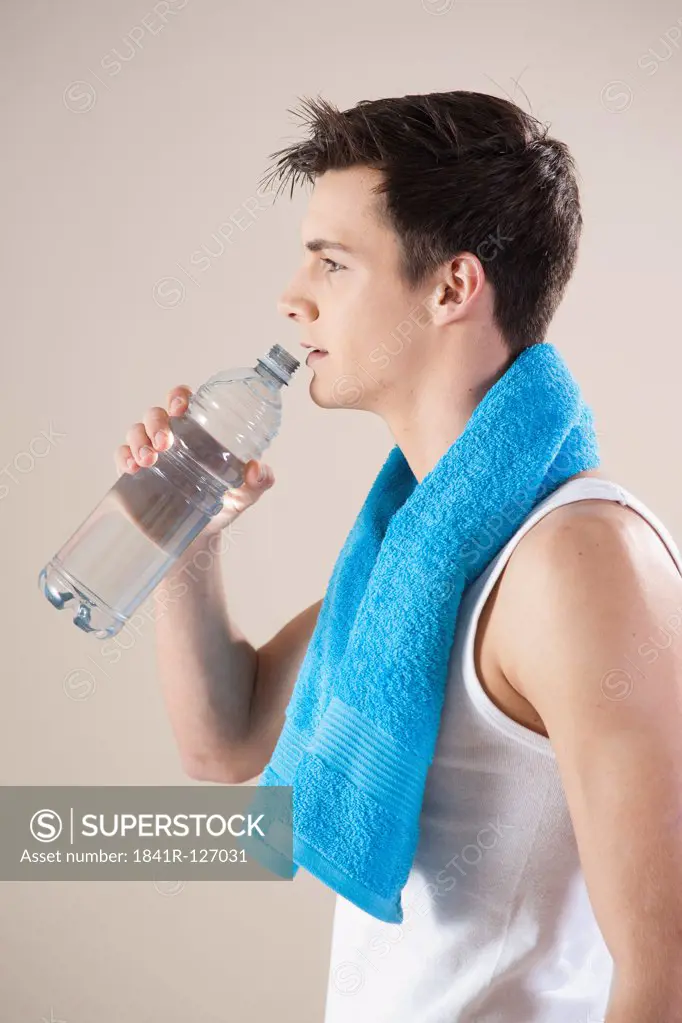 young man drinking from a water bottle