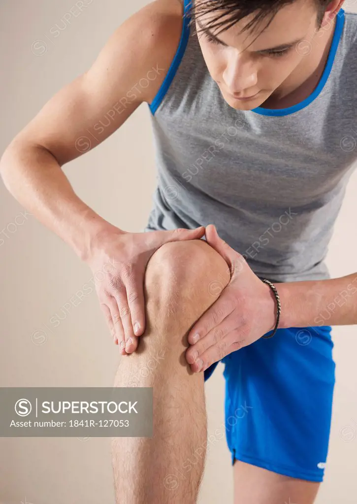 young man touching his knee