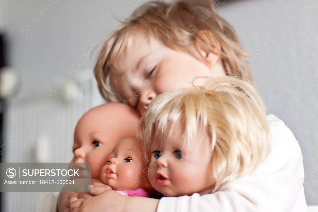 Blond girl embracing her puppets