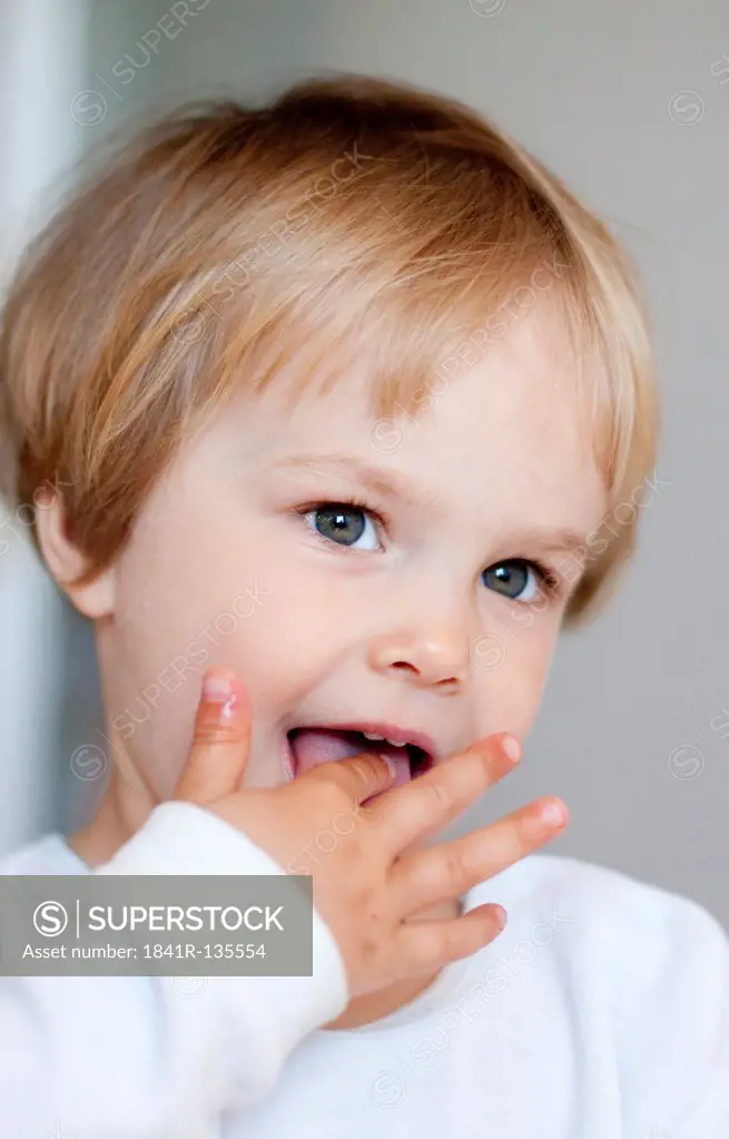 Little blond girl with finger in mouth