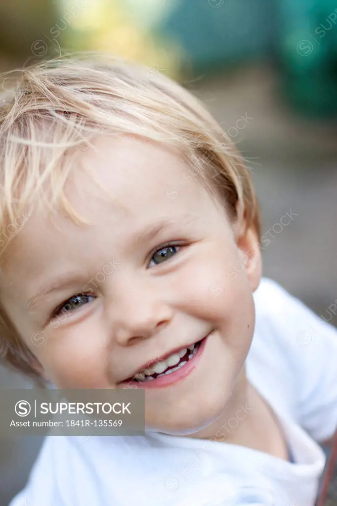 Smiling blond girl outdoors, portrait