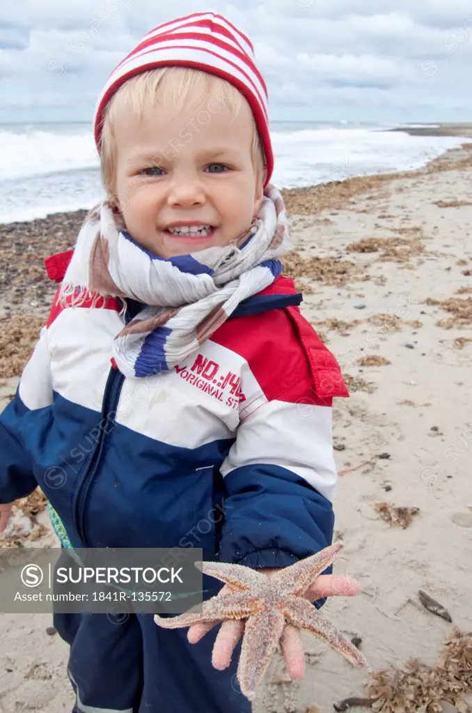 Little girl with starfish at the ocean