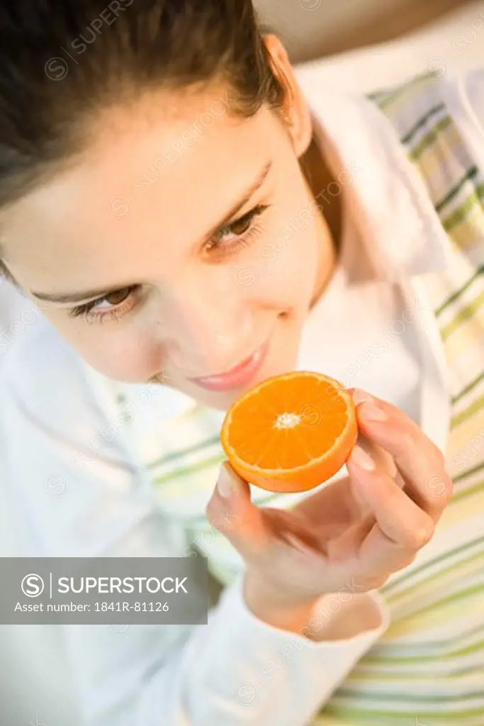 Teenage girl holding orange and smiling