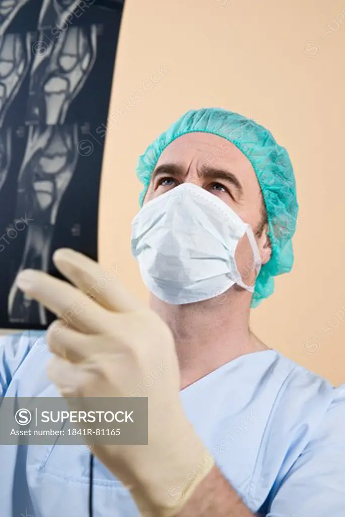 Male surgeon examining x-ray