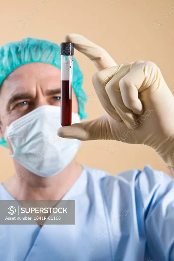 Male surgeon holding vial