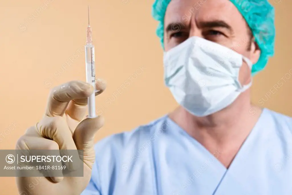 Male surgeon holding syringe