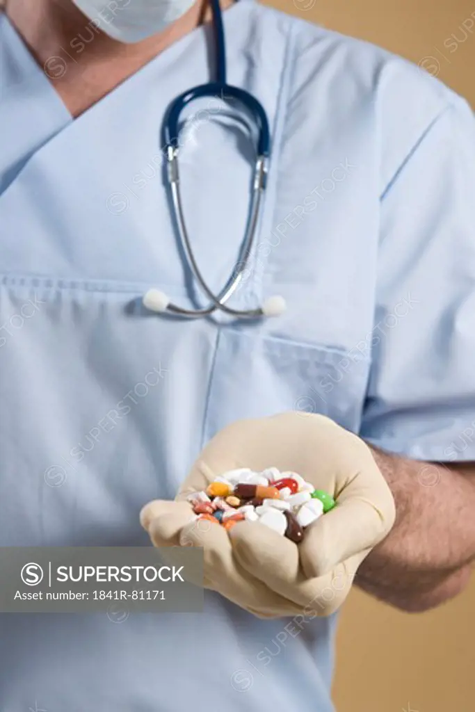 Male surgeon holding pills