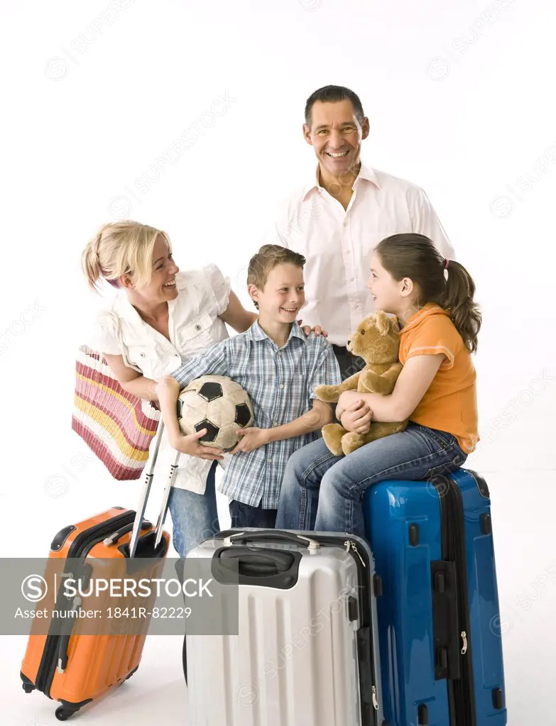 Family with two children with luggage, studio shot