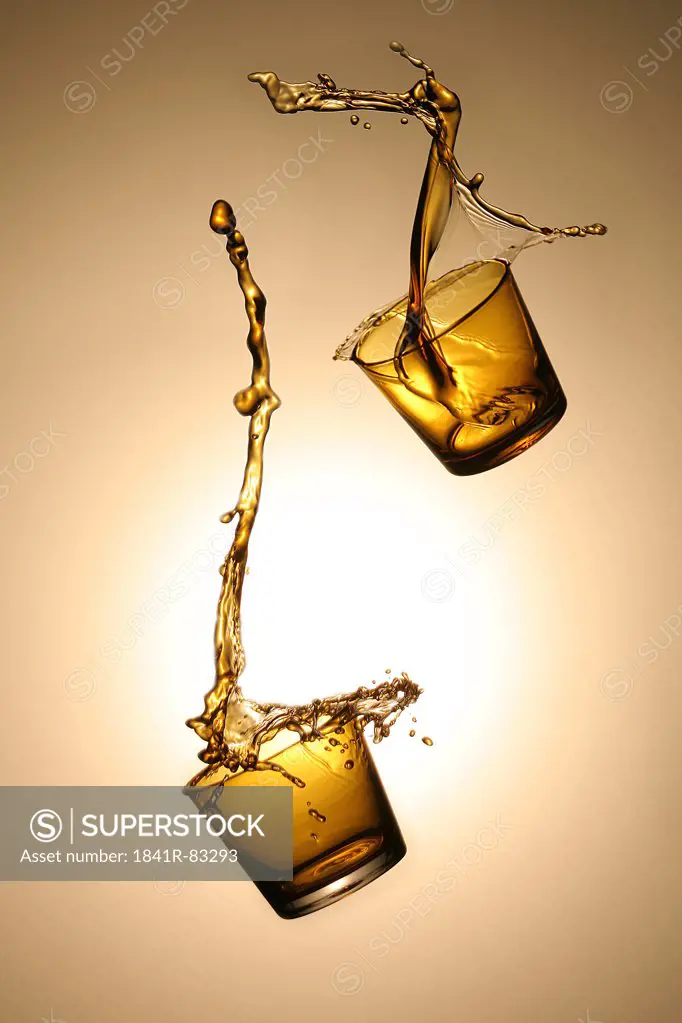 Two whisky glasses in the air