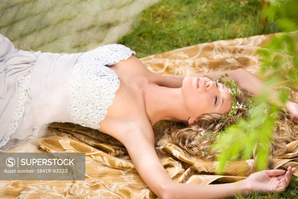 Woman lying on a blanket outdoors, high angle view