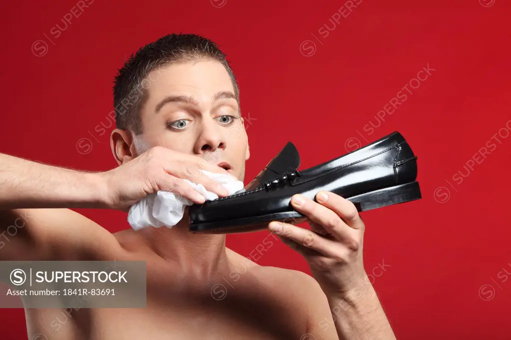 Young man polishing a shoe