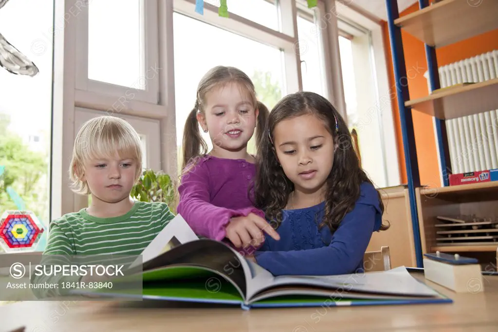 Children looking at picture book, low angle view