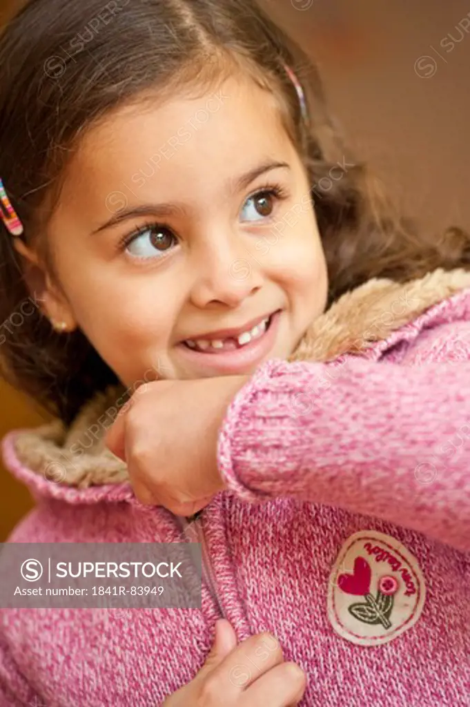 Young girl closing the zipper of her jacket, portrait