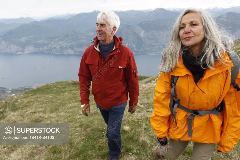 Senior couple hiking in mountain range, Italy