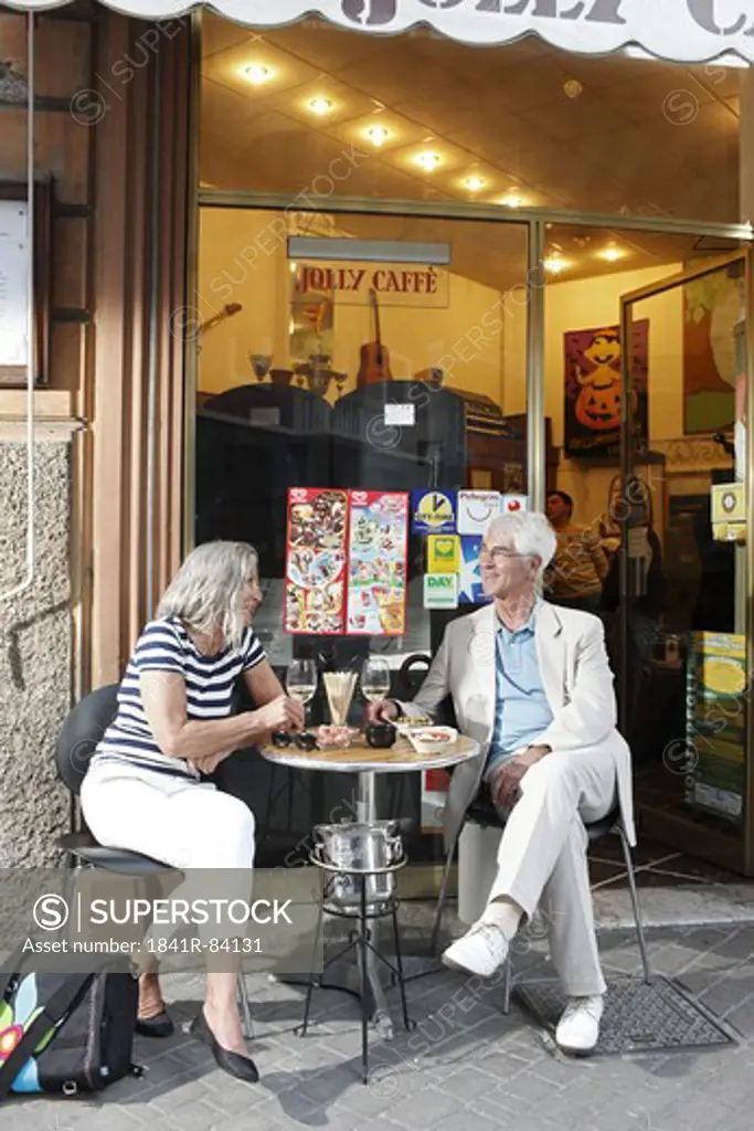 Senior couple in a sidewalk cafe, Italy