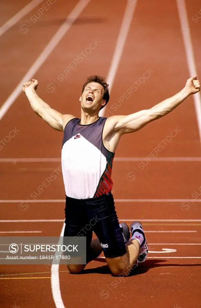 Man stretching his arms on running track
