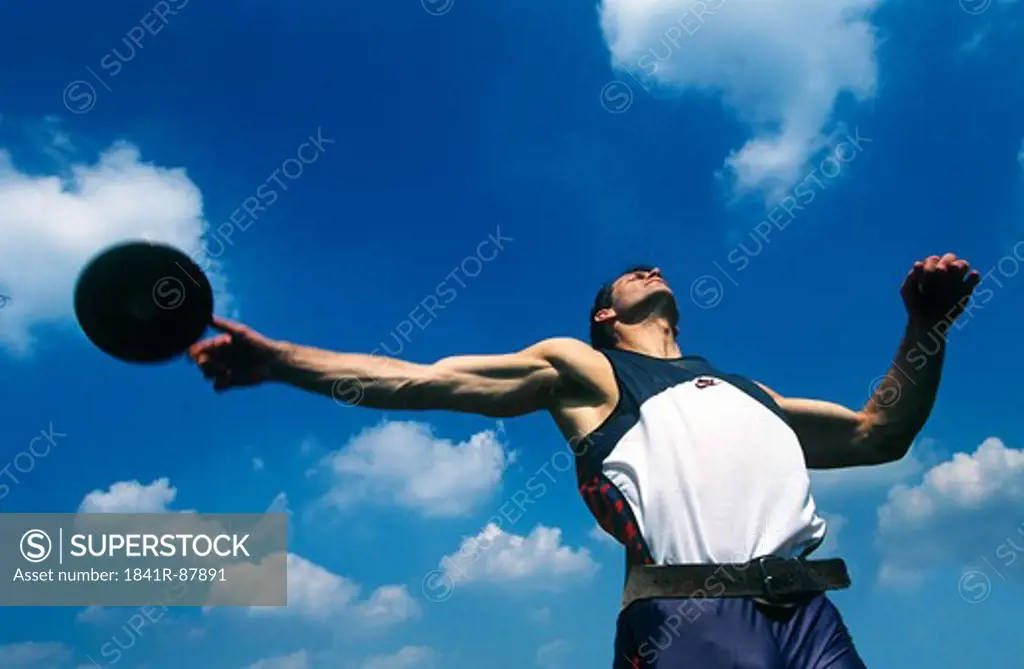 Low angle view of athlete throwing discus
