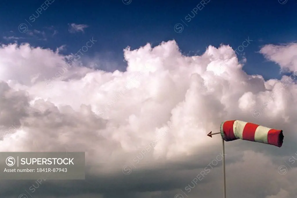 Weather vane against cloudy sky