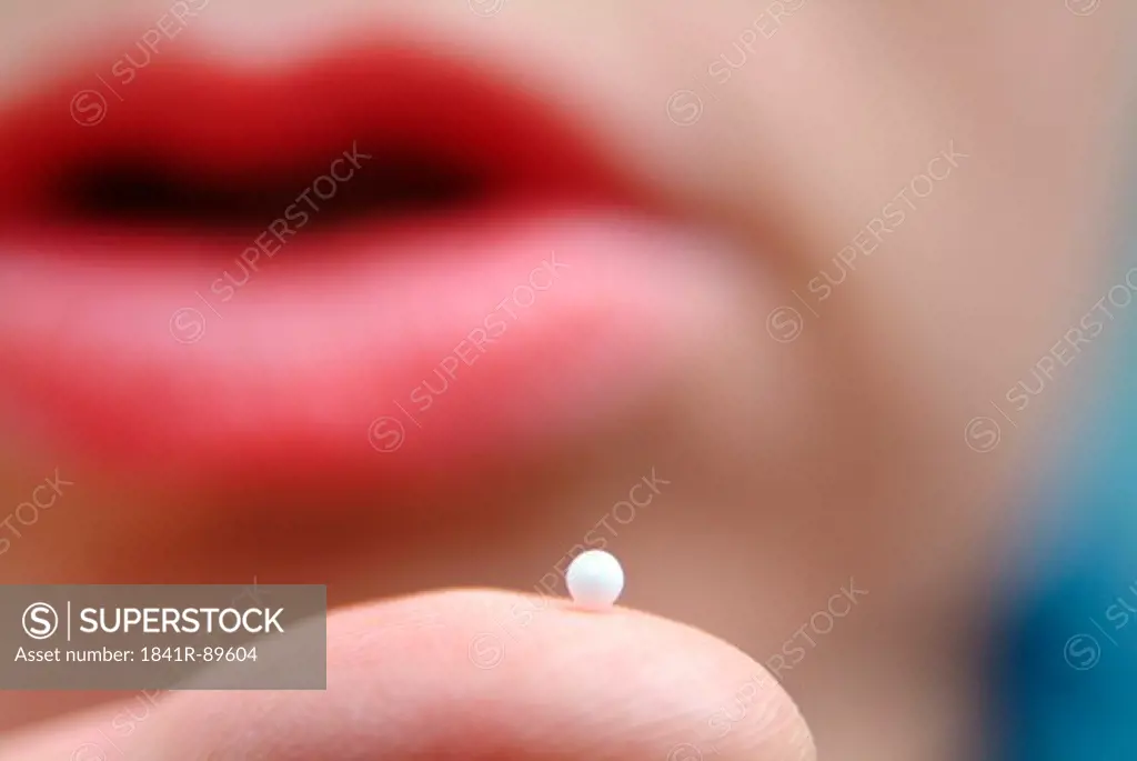 Close-up of pill on finger