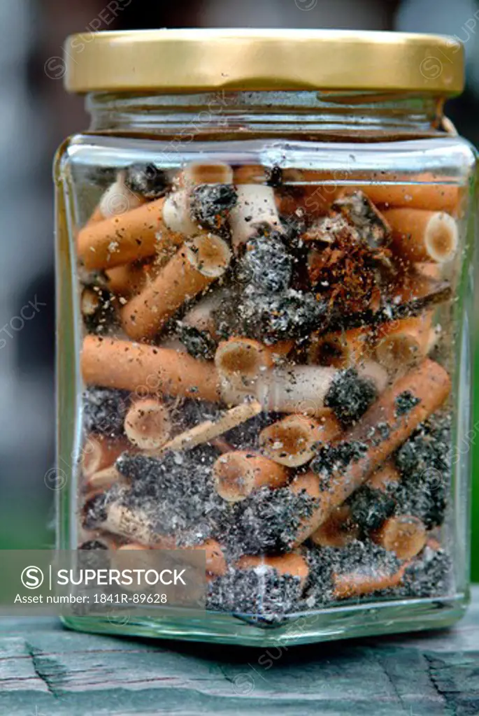 Close-up of jar of cigarette butts