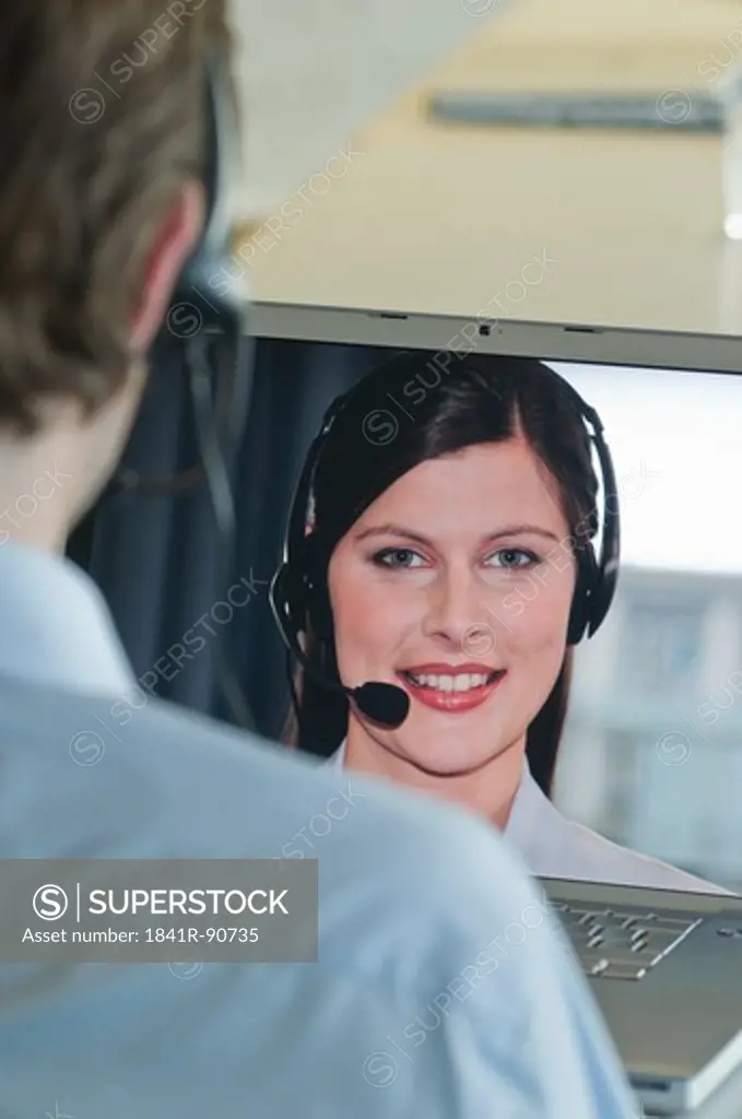 Male customer service representative working on laptop