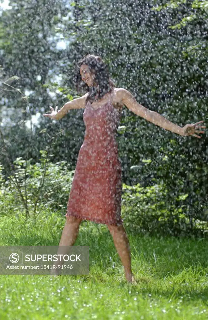 Woman standing in rain in park