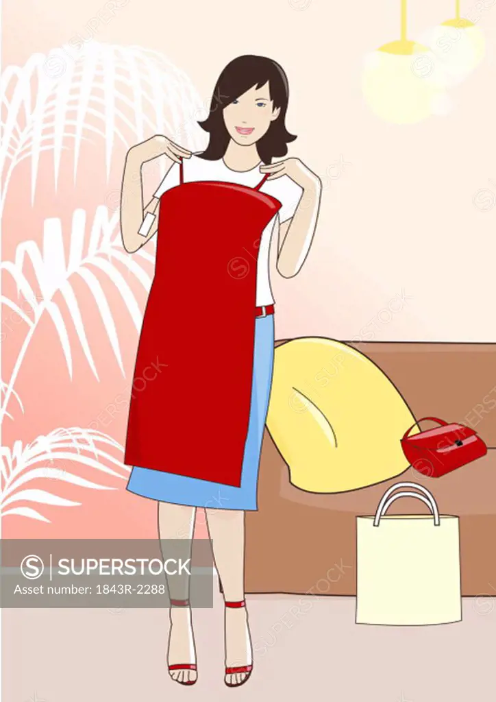 Young woman holding up a red dress in a clothes store
