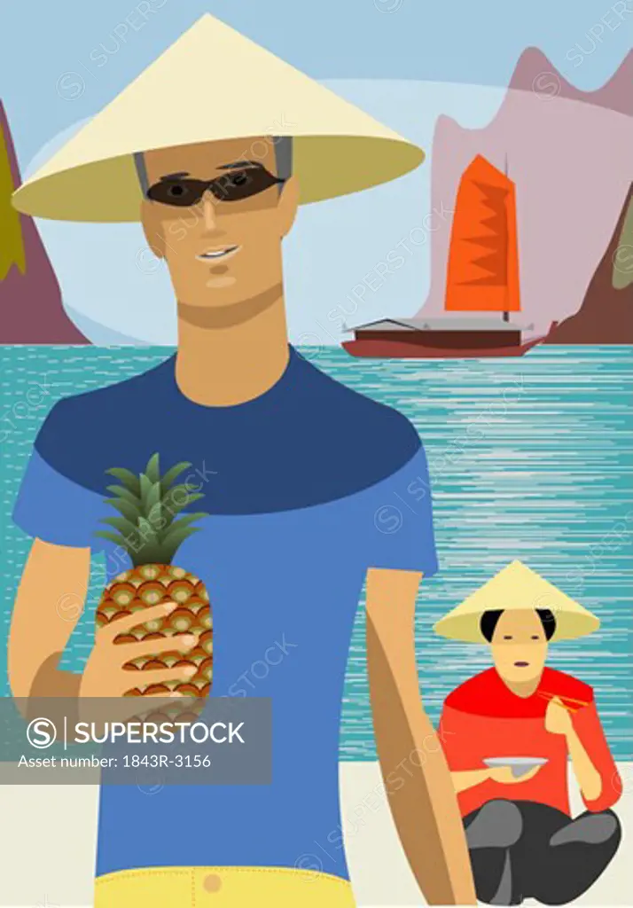 Young man wearing Asian hat on the beach with Asian woman in background