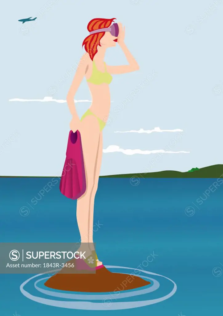 Young woman standing on tiny islet with flippers and mask