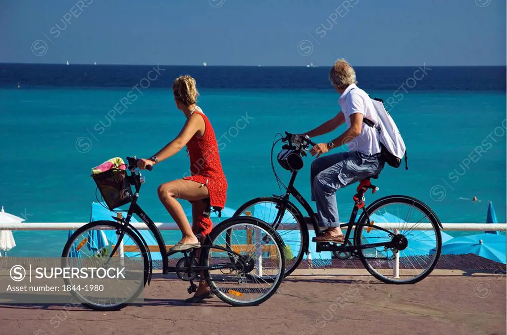 Couple riding past HI Hotel beach _ promenade des anglais. Nice, Provence_Alpes_Cote d´Azur, France, Europe