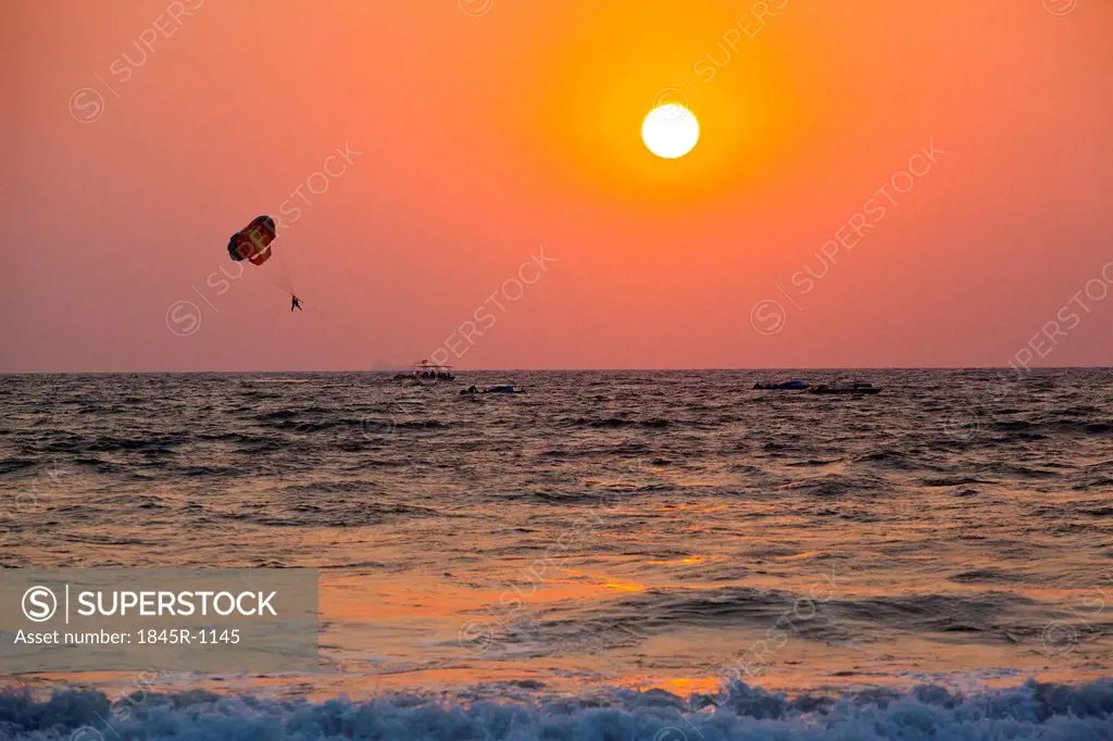 Silhouette of a person parasailing over the sea, Panjim, Goa, India