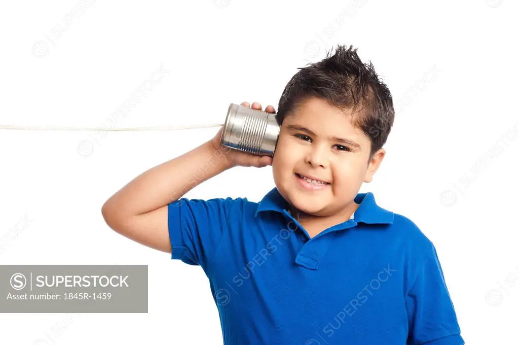 Close-up of a boy listening to a tin can phone