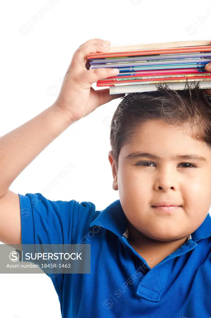 Boy holding a stack of books over his head