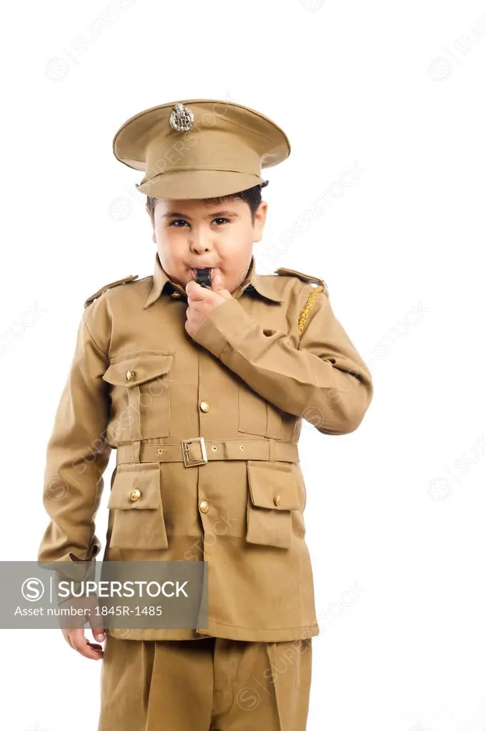 Close-up of a boy dressed as a police uniform blowing a whistle