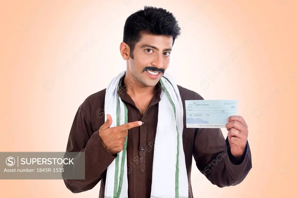 Portrait of a man pointing to a bank cheque and smiling