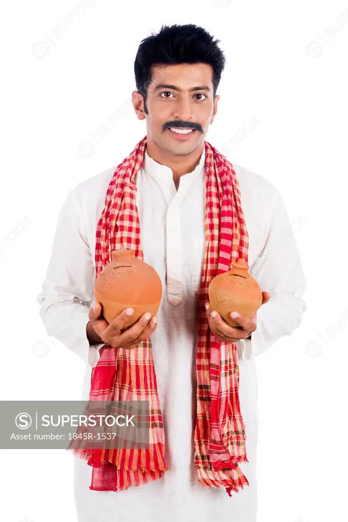 Portrait of a man carrying piggy bank in both hands